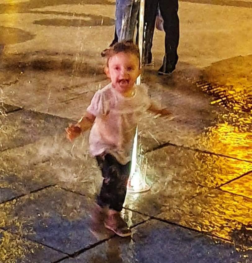 child playing in fountain