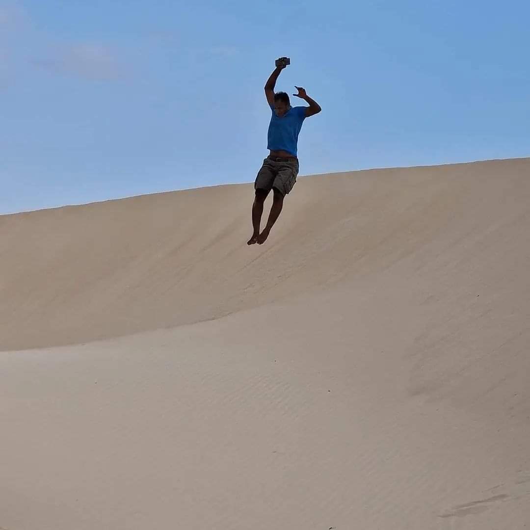 Our guide jumping down a sand dune in Socotra