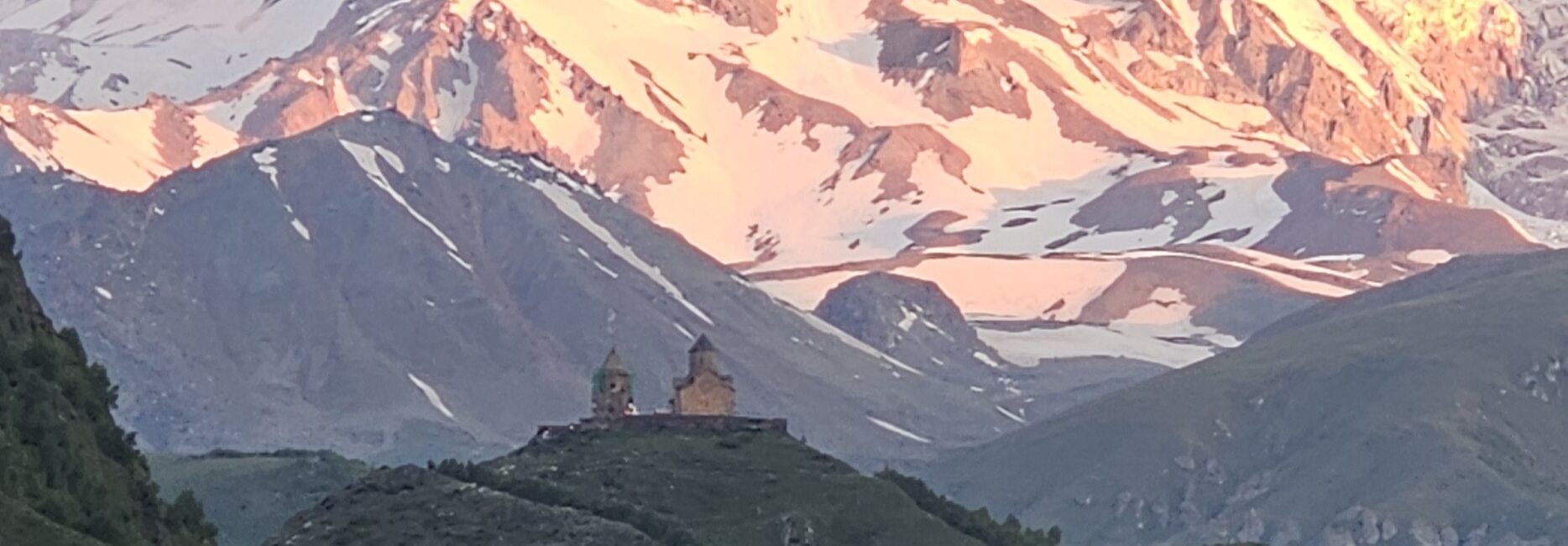 The sunrise over Mount Kazbegi and Gergeti Trinity Church in Kazbegi, Georgia